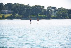 Two people on stand-up paddle boards on a pond