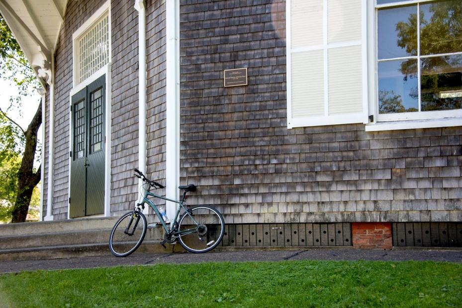 A bicycle leans against a shingled wall. Photo by Timothy johnson